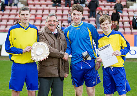 Declan Boyle, goalkeeper Nathan Harkin and and Declan Wilson receiving the trophy from Interim Chairman Bob Garmory Declan Boyle, goalkeeper Nathan Harkin and and Declan Wilson receiving the trophy from Interim Chairman Bob Garmory
